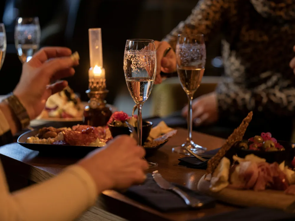 To mennesker spiser middag på restaurant og drikker vin