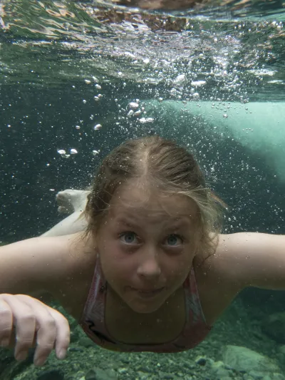 Jente som svømmer under vann.