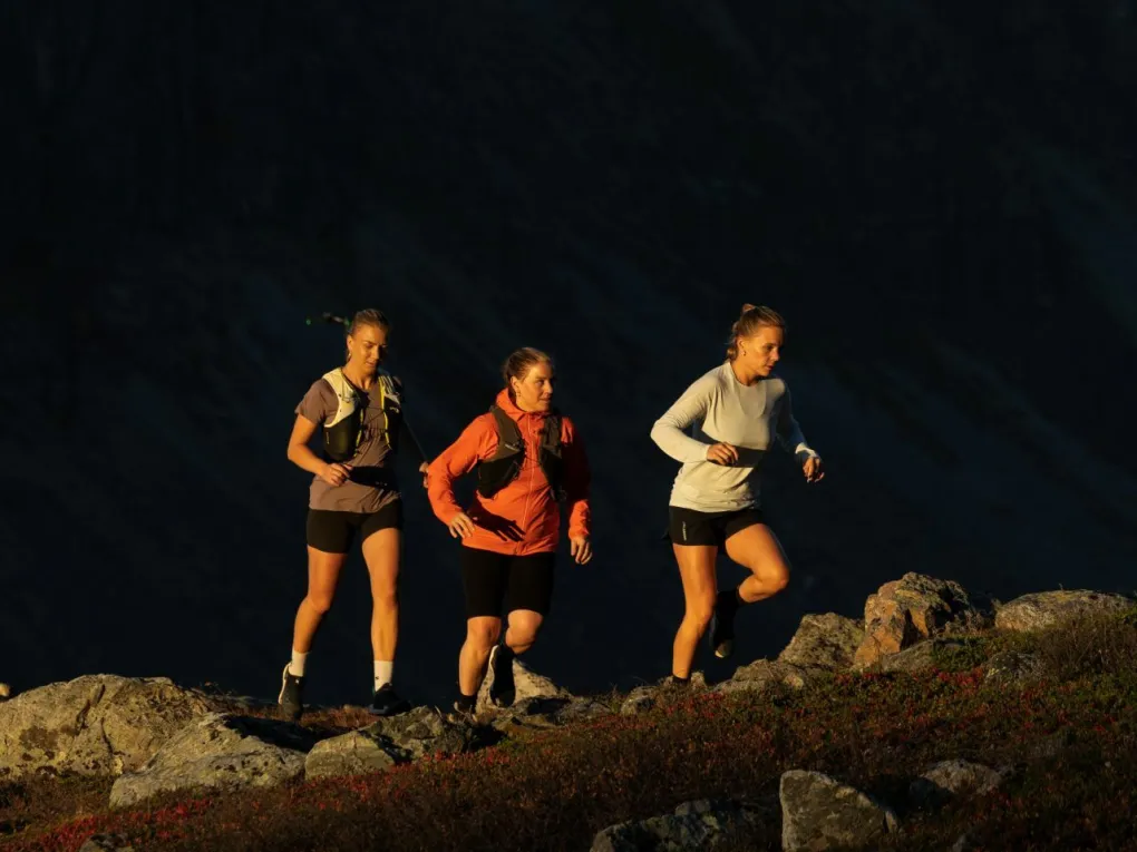 Damer som løper i fjellet når det er mørkt.