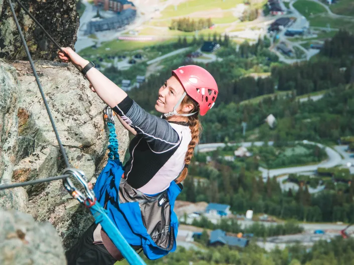 Dame som bestiger Via Ferrata i Hemsedal
