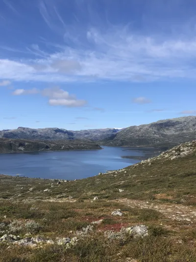 Utsikt utover fjell og vann, fint vær.