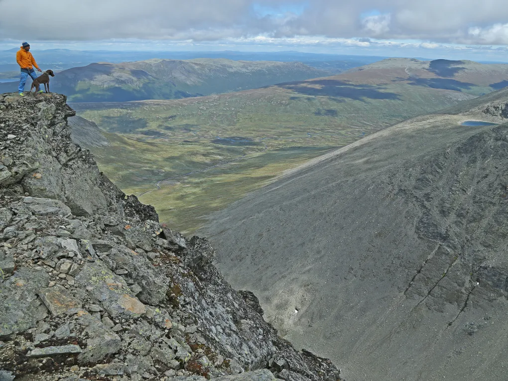 Mann og en hund på toppen av et fjell i Hemsedal