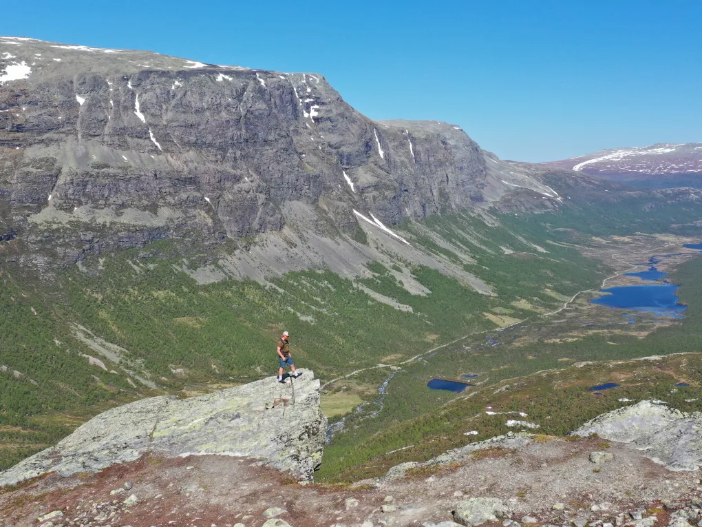 Mann på toppen av utsiktspunkt, fint vær (sommer).