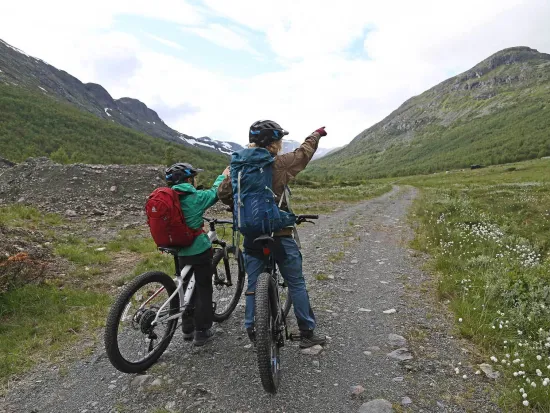 To mennesker som peker opp på fjellet foran dem