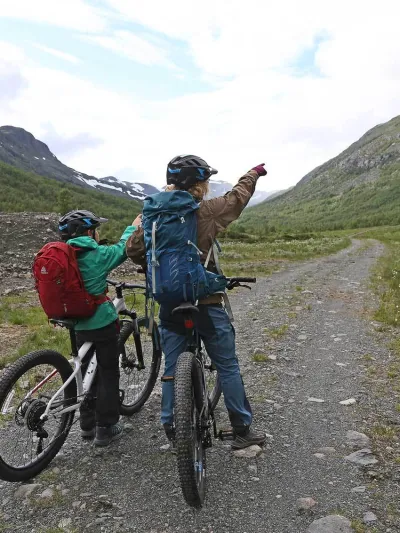 To mennesker som peker opp på fjellet foran dem
