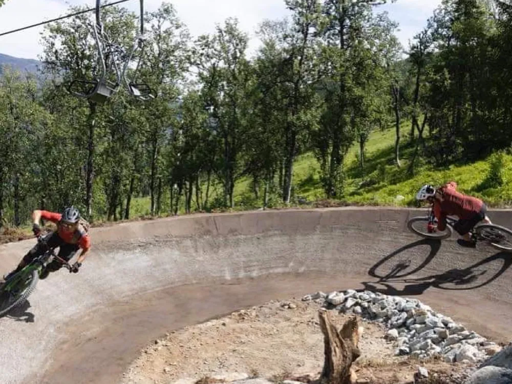 To mennesker som kjører i en skarp sving i Hemsedal skisenter