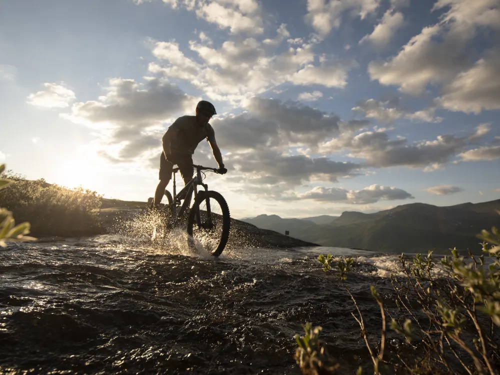 Mann som sykler oven en bekk i Hemsedal sine sykkelløyper 2