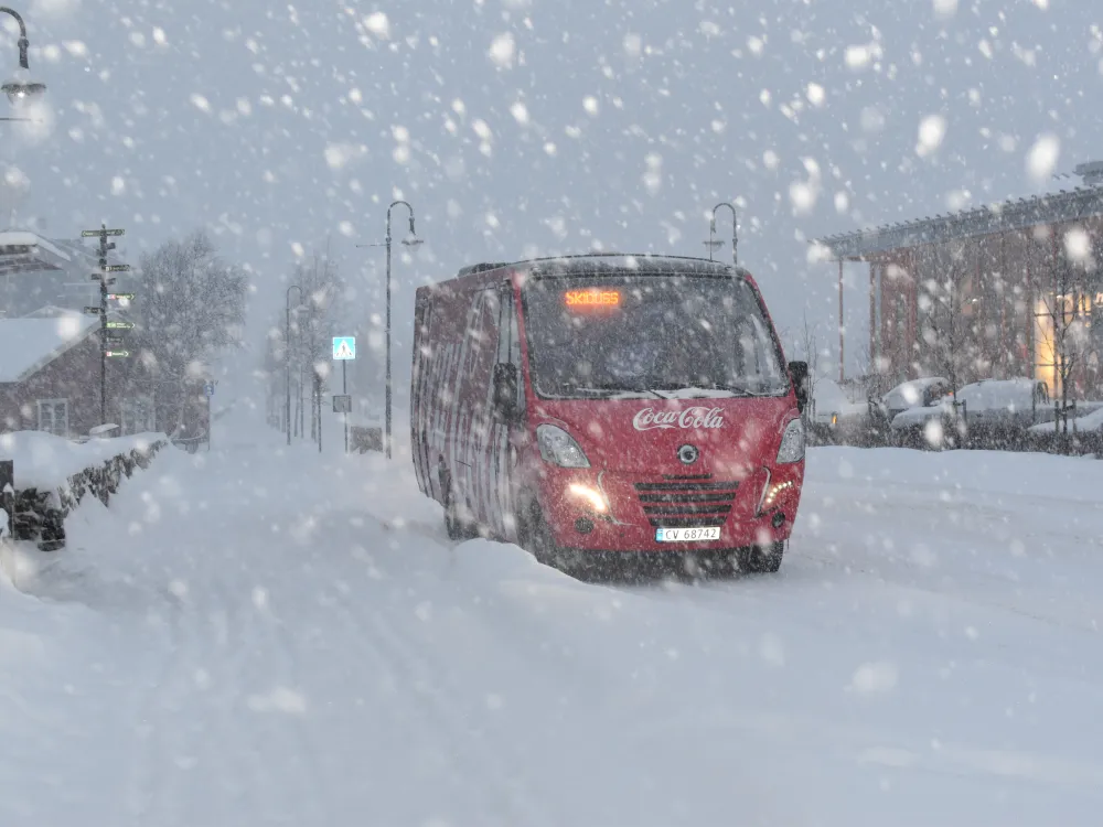 Cola skibuss ved busstoppet i sentrum om vinteren.