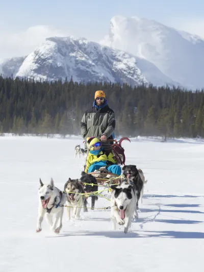 Mann og barn som kjører hundekjøring om vinteren i Hemsedal