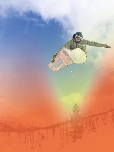 En gutt som tar et triks på snowboard i skibakken.